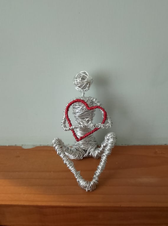 Figure Holding onto love wire art sculpture 