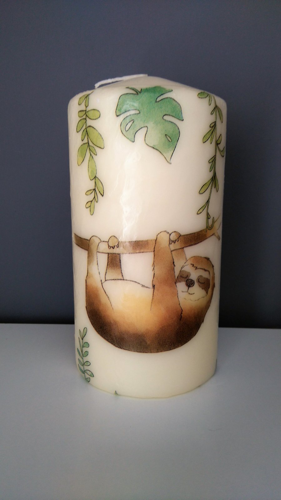 sloth decorated candle