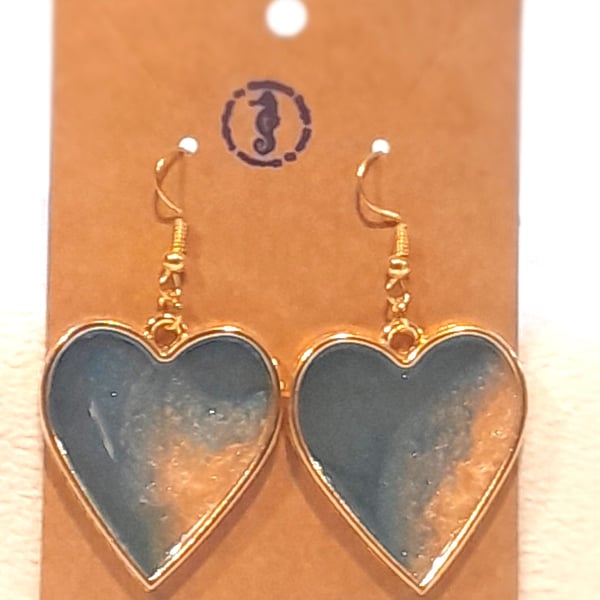 Heart shaped resin earrings filled with blue and gold resin