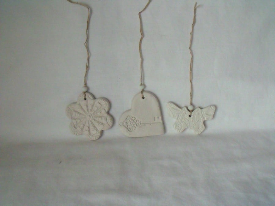 set of three impressed ceramic hanging decorations, unpainted