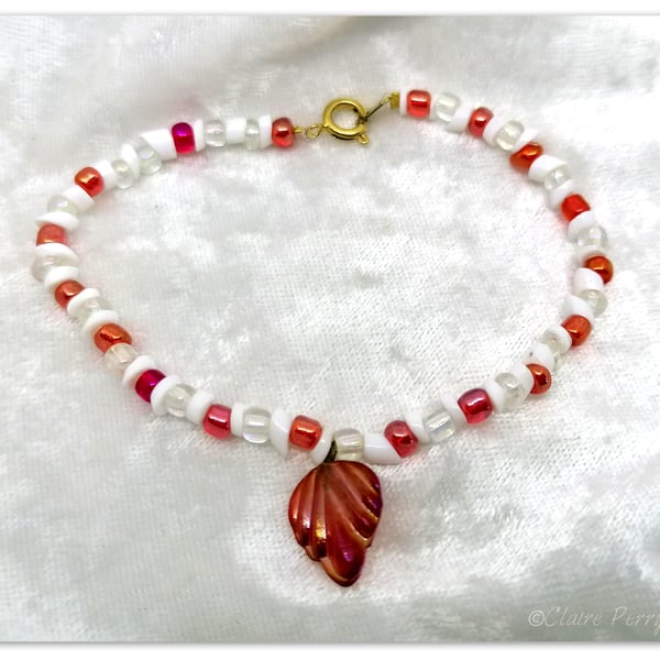 Seed bead bracelet with red and white glass beads with a red glass charm.