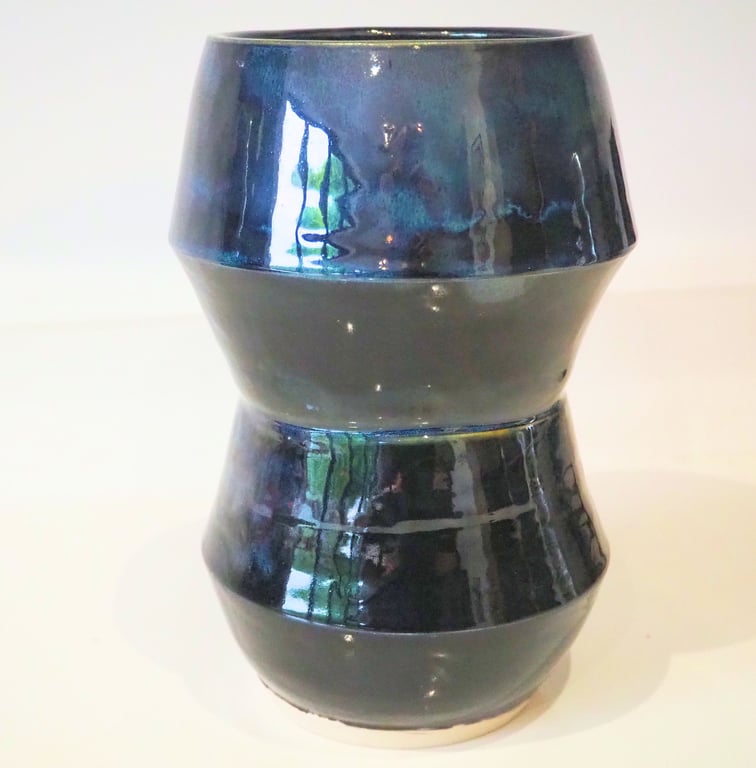 Ceramic tall angular black vase with blue, green accents. 