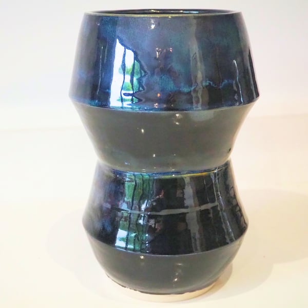 Ceramic tall angular black vase with blue, green accents. 