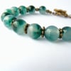 Variegated green jade bracelet, with bronze clasp