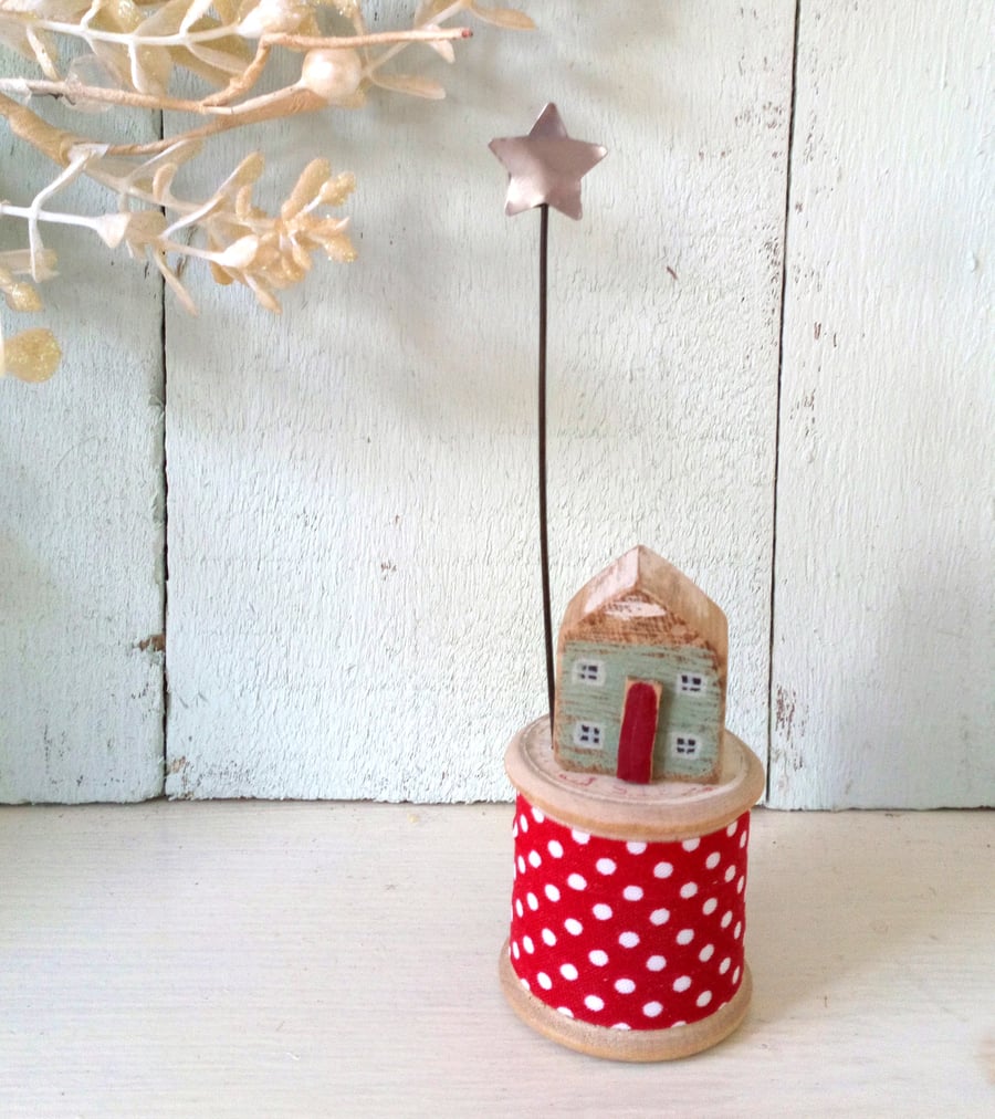 Little wooden house with Christmas star on vintage bobbin