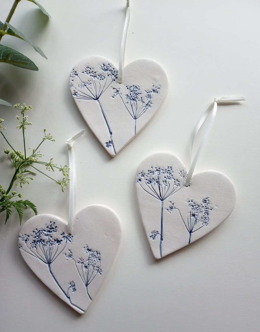 Set of 3 ceramic heart hangings with a botanical print.