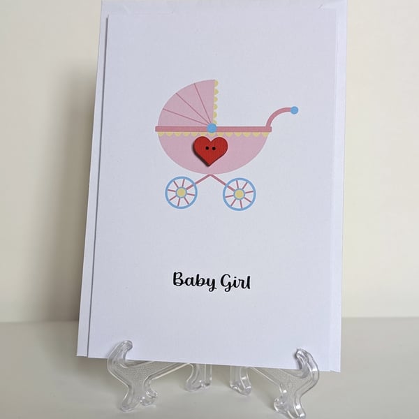Baby girl pram with red heart button greetings card 
