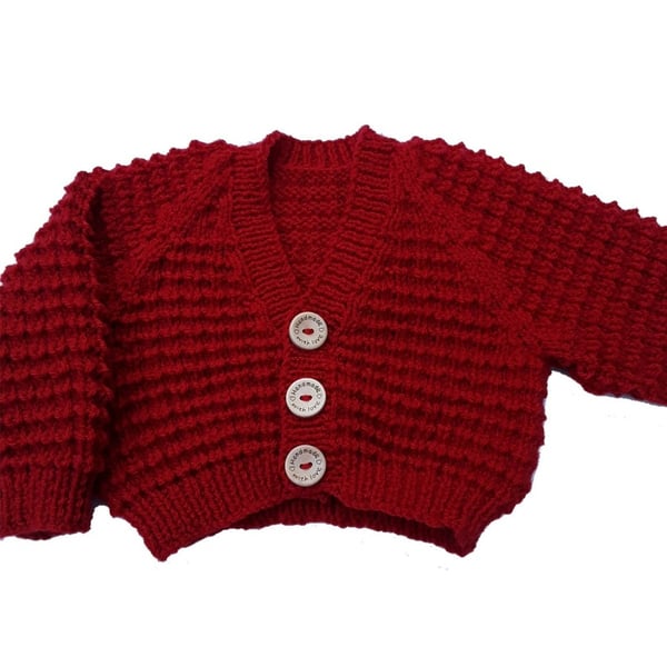 Hand knitted baby cardigan in fox red brown textured pattern 