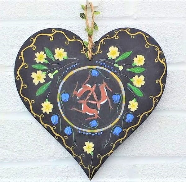 Hares and primroses on a wooden heart