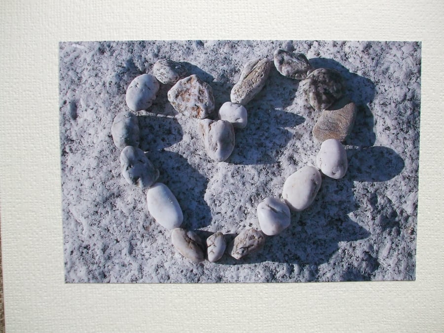 Landscape photographic card with pebbles in a heart shape.