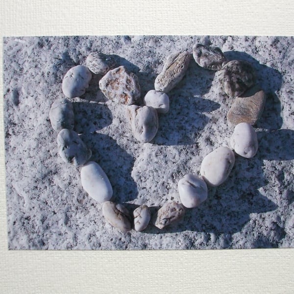 Landscape photographic card with pebbles in a heart shape.