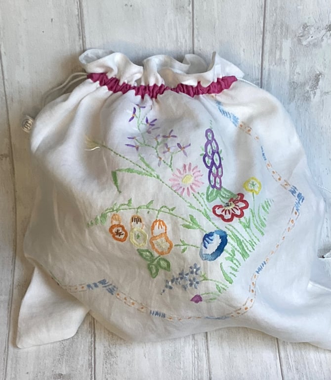 Travel packing laundry bag made from a hand embroidered cloth. Pink trim