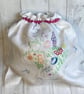 Travel packing laundry bag made from a hand embroidered cloth. Pink trim