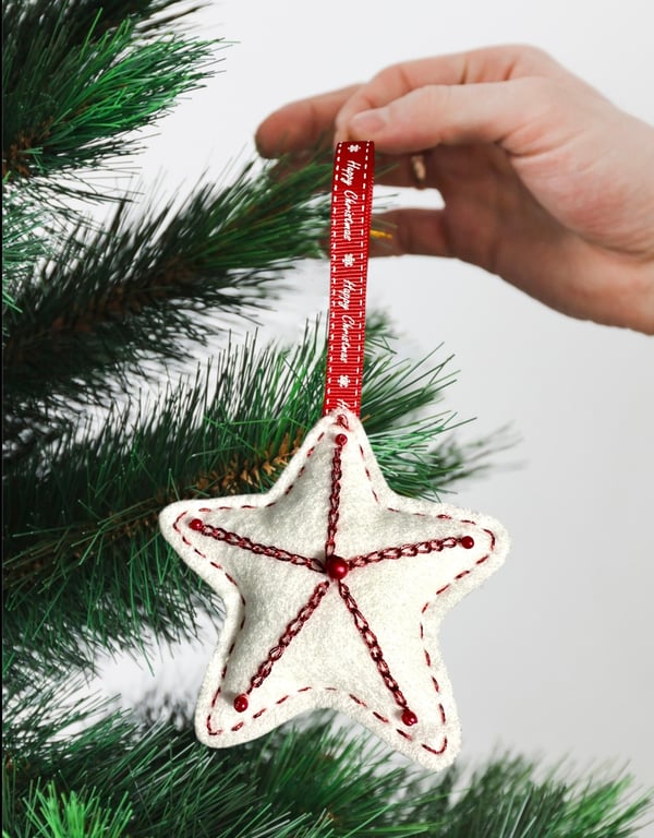 A Red and white star tree decorations with metallic thread and seed beads 