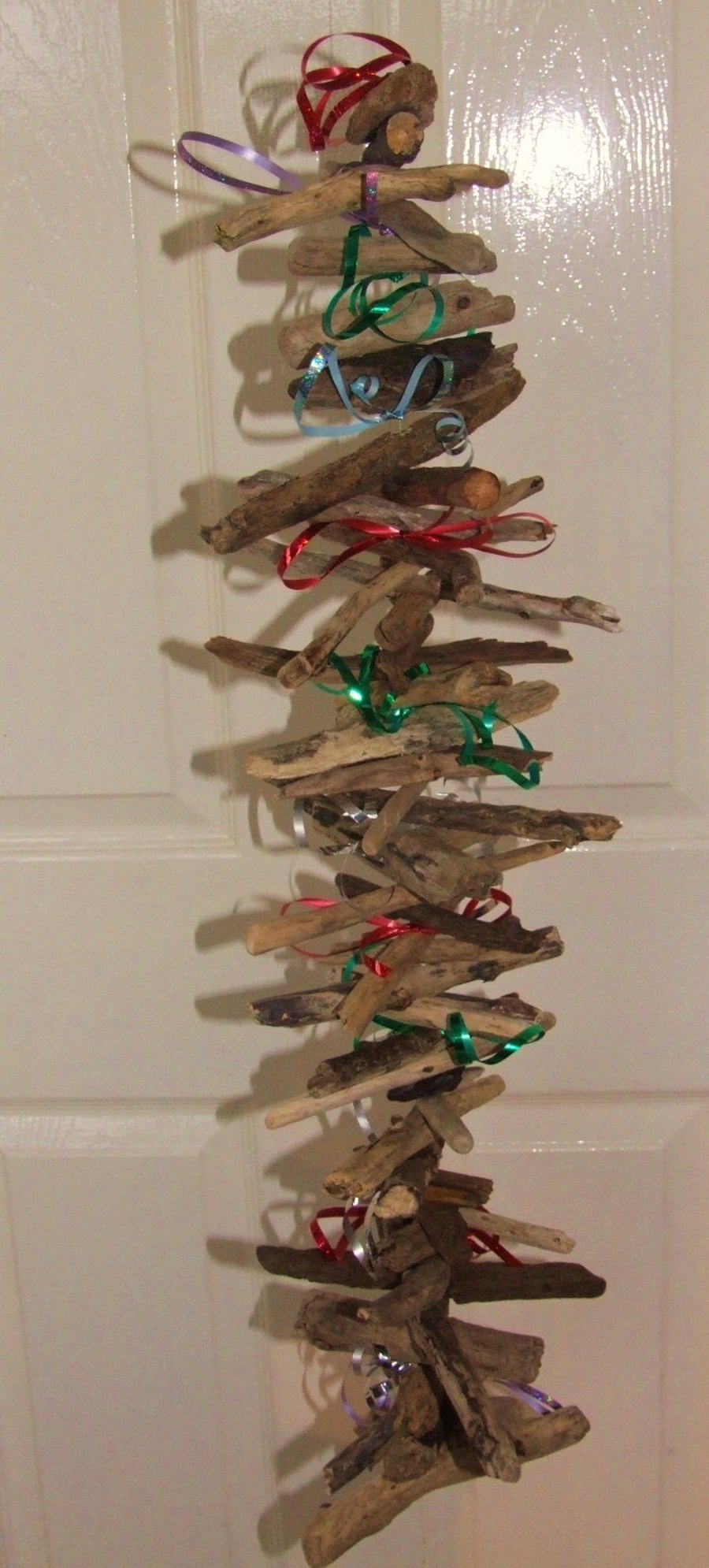 Driftwood wallhanging decoration with tinsel or ribbon for Christmas festivities