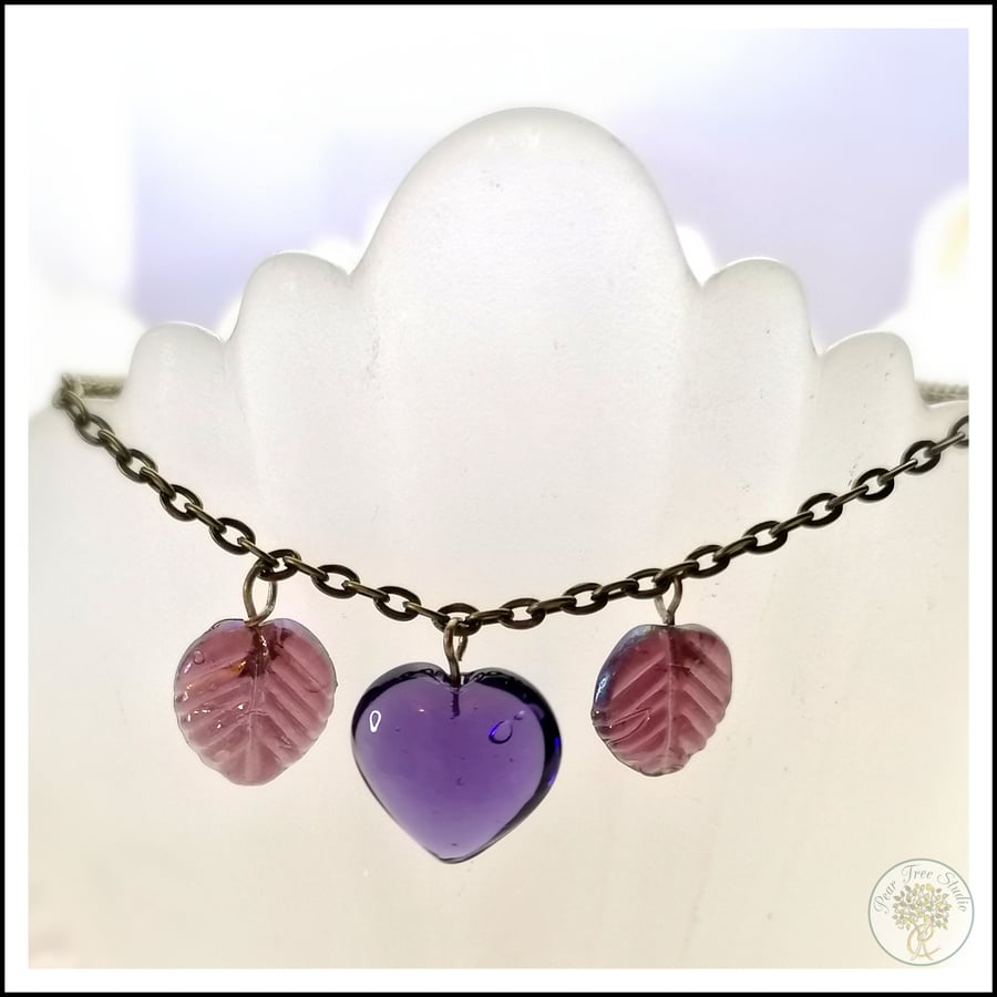 Handmade necklace with light purple glass leaf beads and a dark purple heart
