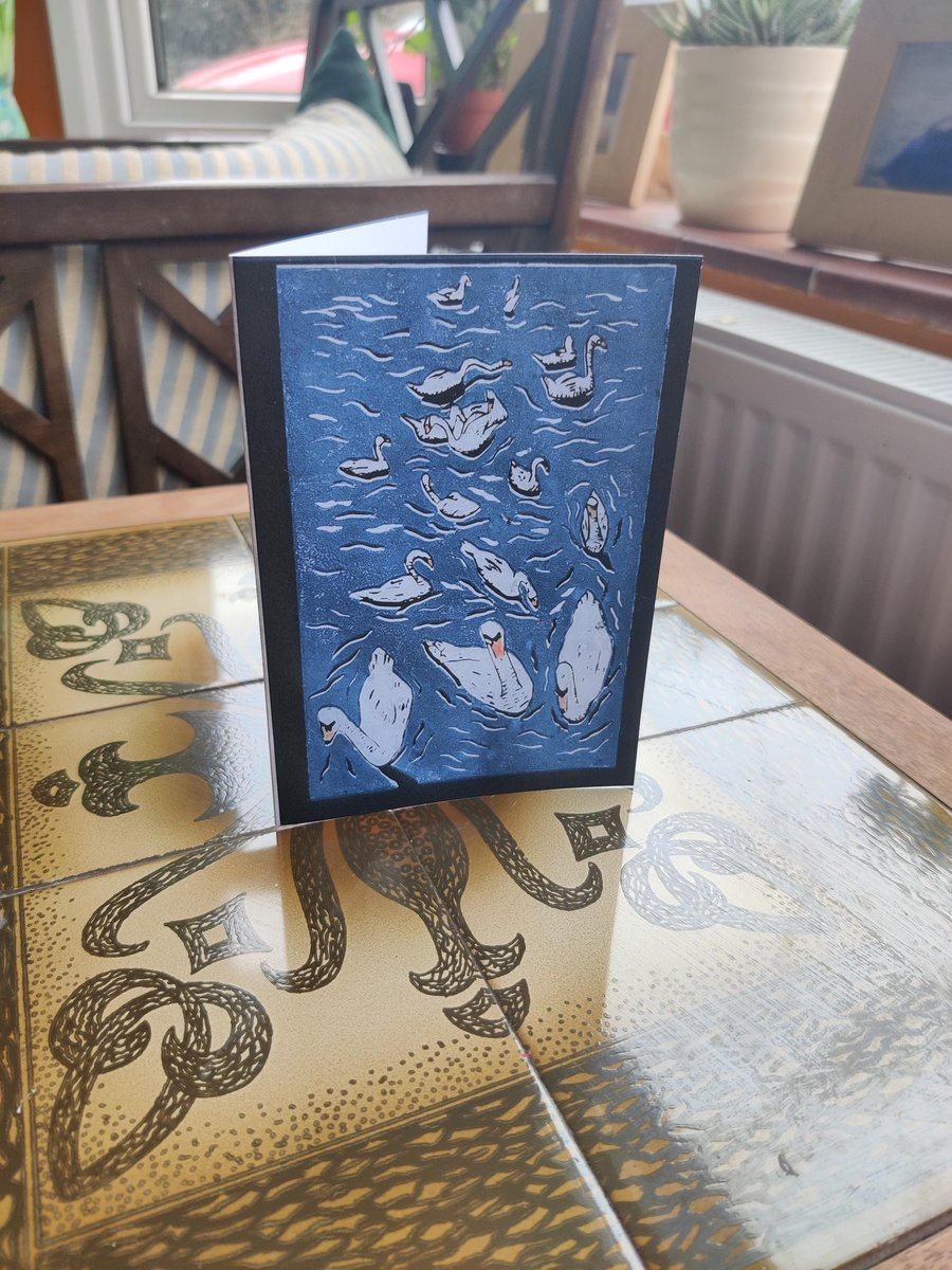 A beautiful reproduction print showing swans swimming on the local lake