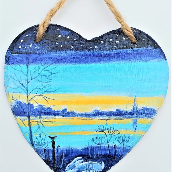 Hare snoozing beside a sunset river  on slate