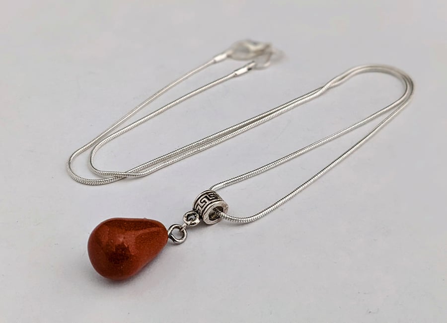 Brown goldstone pendant on silver snake chain