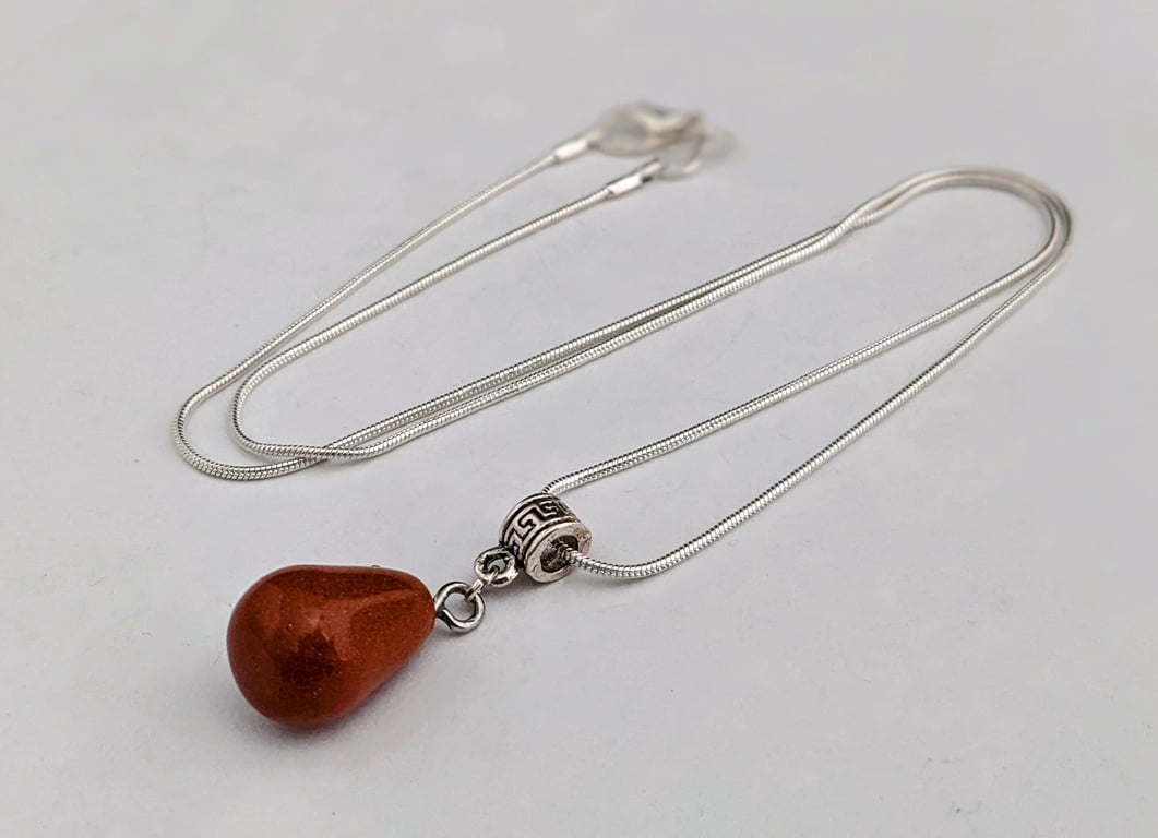 Brown goldstone pendant on silver snake chain