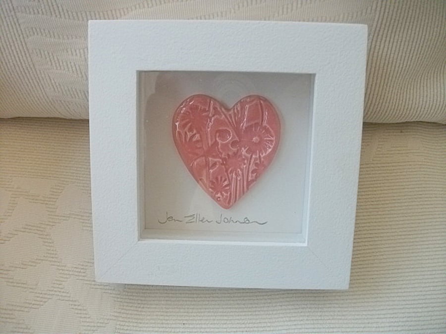 Ceramic pink heart impressed with a floral design.  Rustic white wood frame