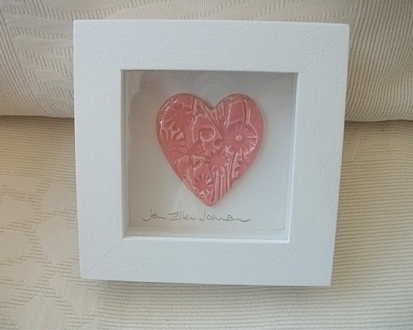 Ceramic pink heart impressed with a floral design.  Rustic white wood frame