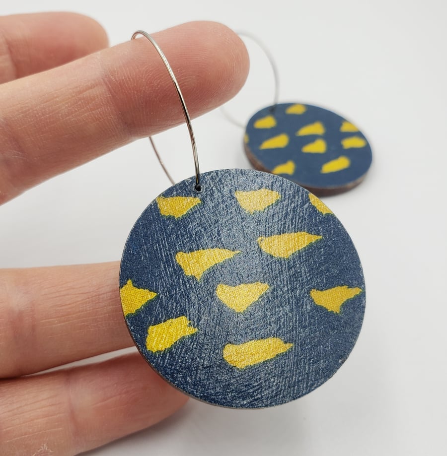 Large bold wooden earrings in navy blue with canary yellow markings