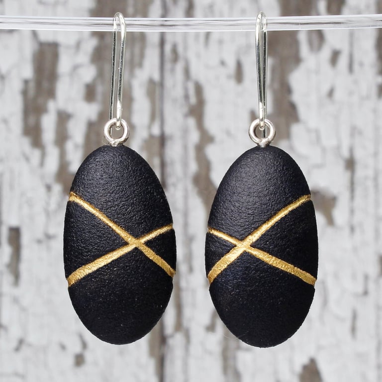 Black pebble earrings, inspired by nature with gold lines and silver earwires