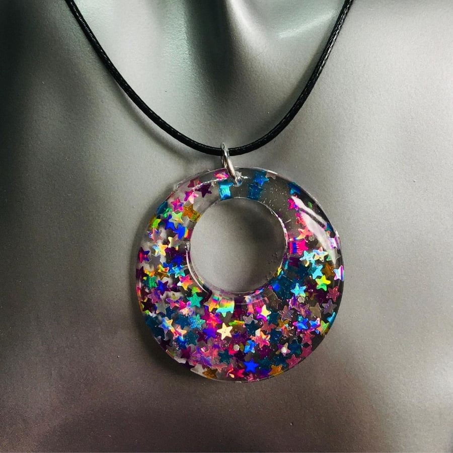 Pink and blue sparkly donut necklace encased in resin.