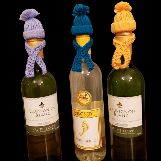 Crocheted bobble hat and scarf bottle toppers