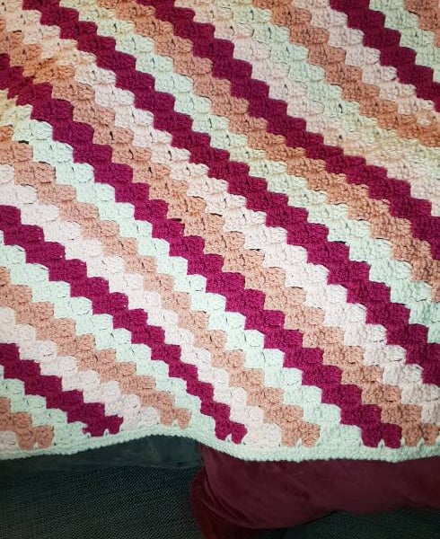 Handmade pink crocheted baby blanket