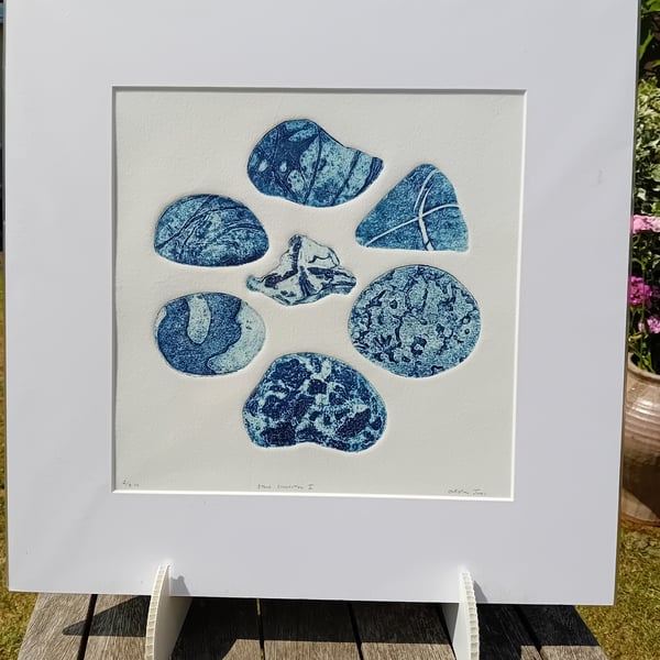 A collagraph print of beach pebbles blue