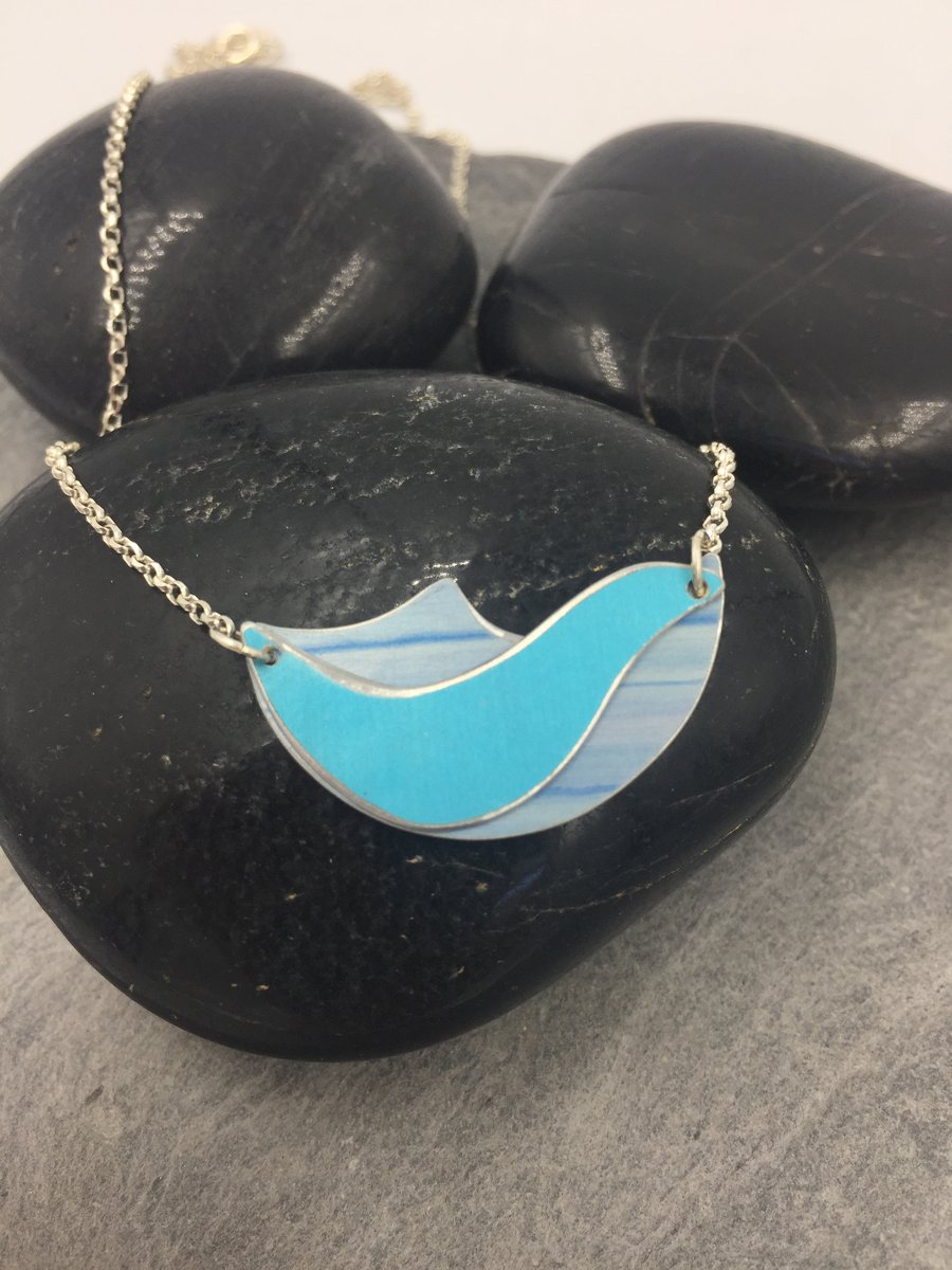 Anodised aluminium ocean wave pendant in shades of blue