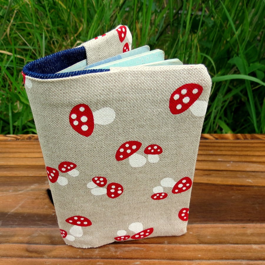 A fabric passport cover with a whimsical toadstool design.