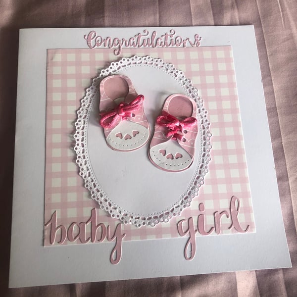 Baby girl pink card for arrival of new baby with cute little booties 