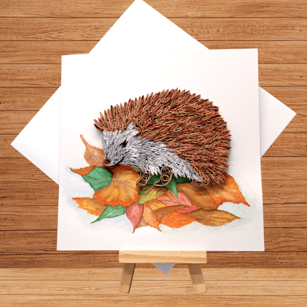 Distinctive quilled hedgehog sitting on hand painted autumn leaves