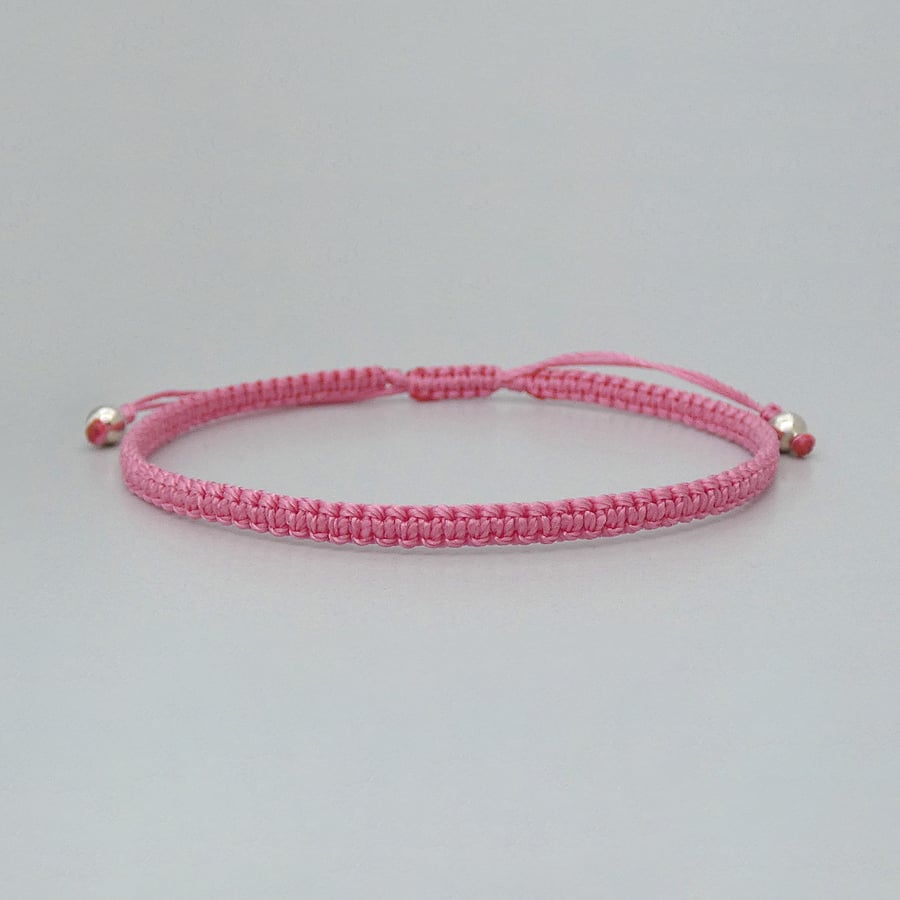 Pink macramé bracelet with silver plated bead ends. Extends from 7” to 9.5