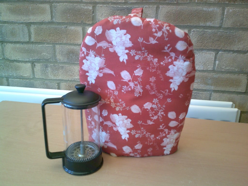 Small Coffee Pot Cosy with White Flowers and Leaves on a Rust Colour Background