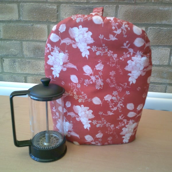 Small Coffee Pot Cosy with White Flowers and Leaves on a Rust Colour Background