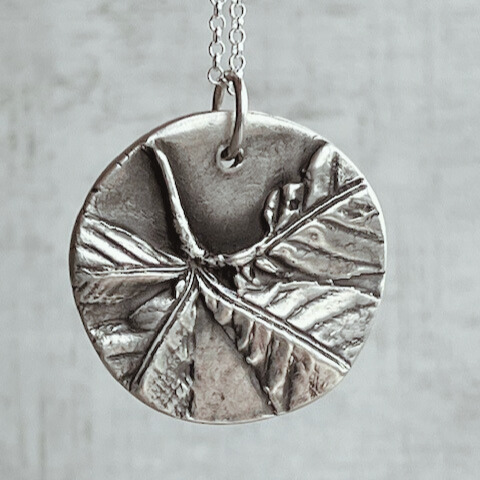 Botanical silver pendant with chestnut leaf design.