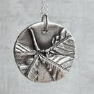 Botanical silver pendant with chestnut leaf design.