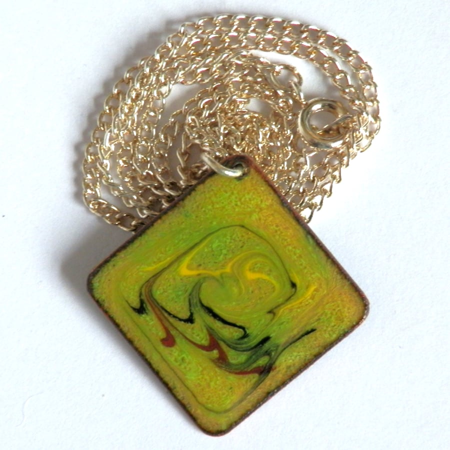 red-brown, black and yellow scrolled on green over clear -  square pendant 