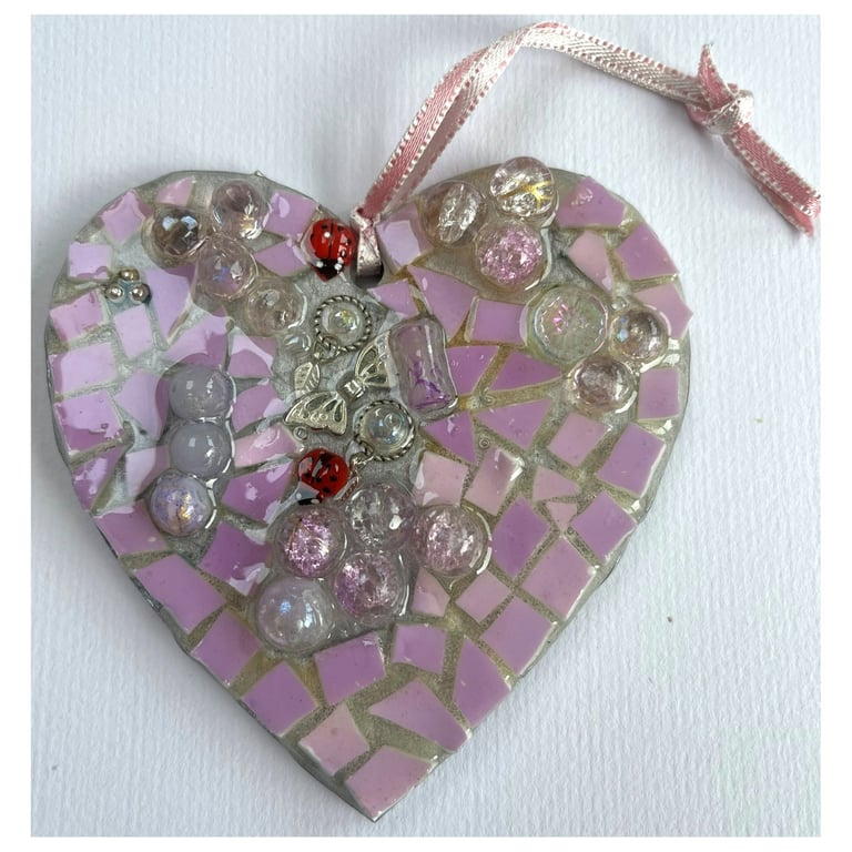 A wooden heart shaped pendant with a light mauve theme.