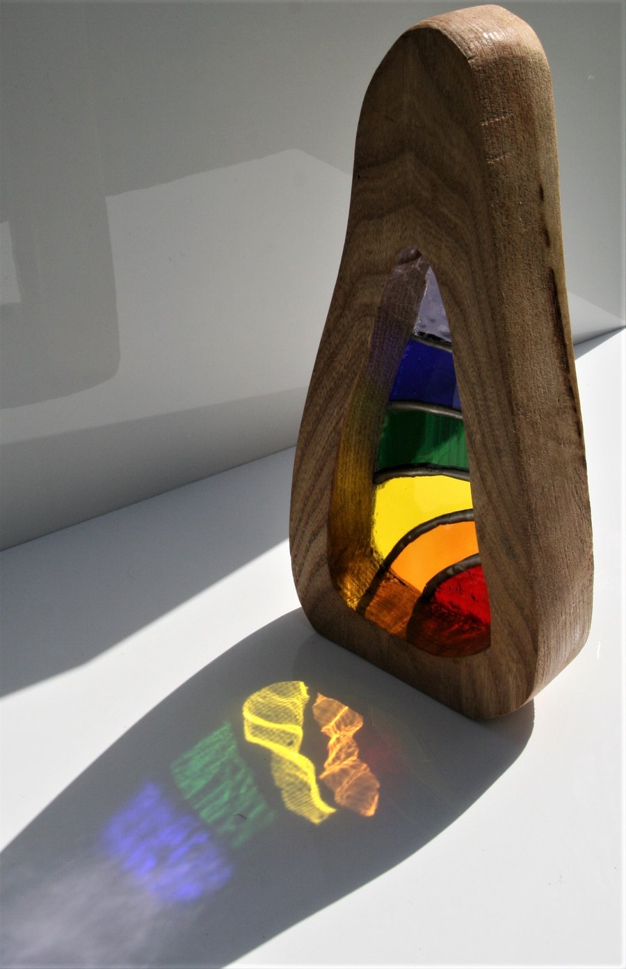 Handmade stained glass sun catcher set inside a solid wood surround.
