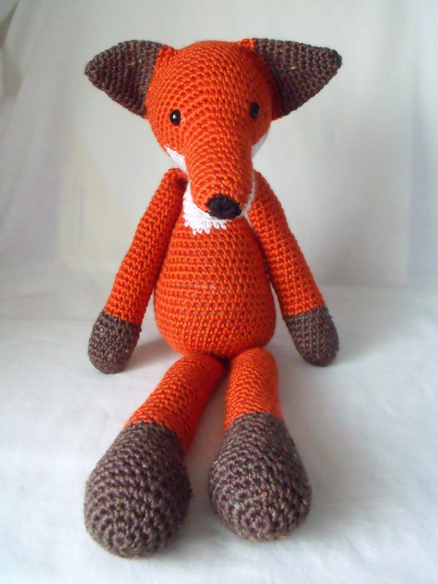 large crocheted amigurumi urban red fox measuring 18 inches long