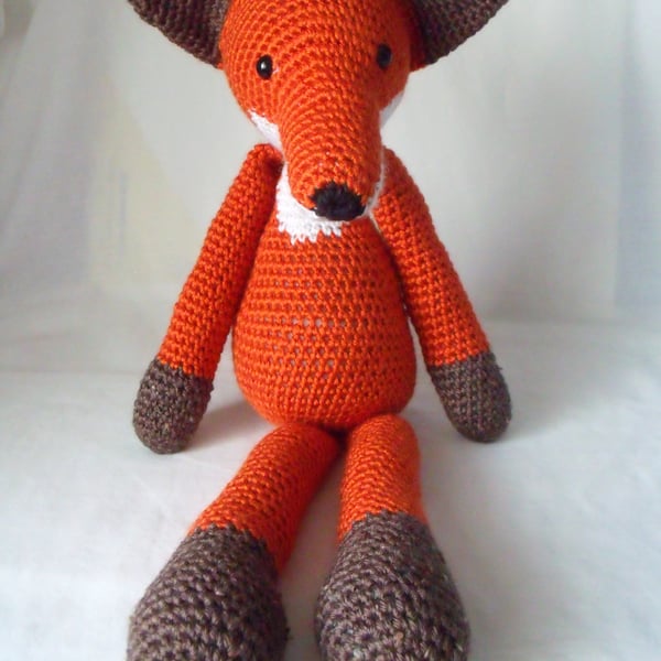 large crocheted amigurumi urban red fox measuring 18 inches long