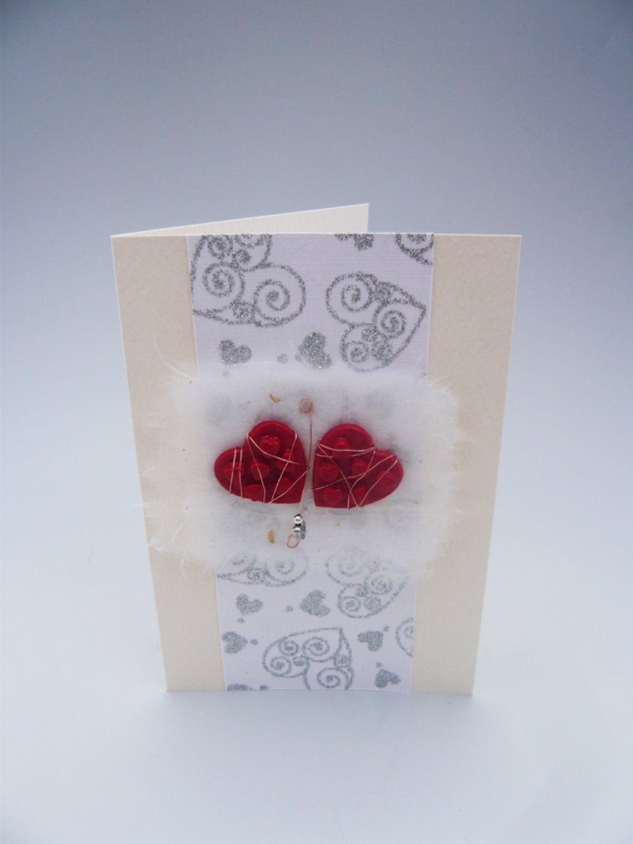Handmade Valentine's Card. Twin hearts with heart bead on silver heart paper.