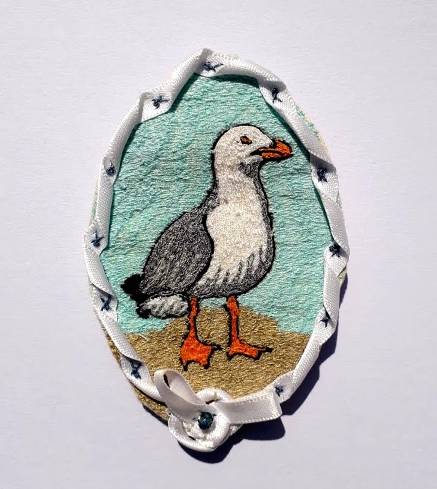 Stitched seagull ribbon edged oval brooch.