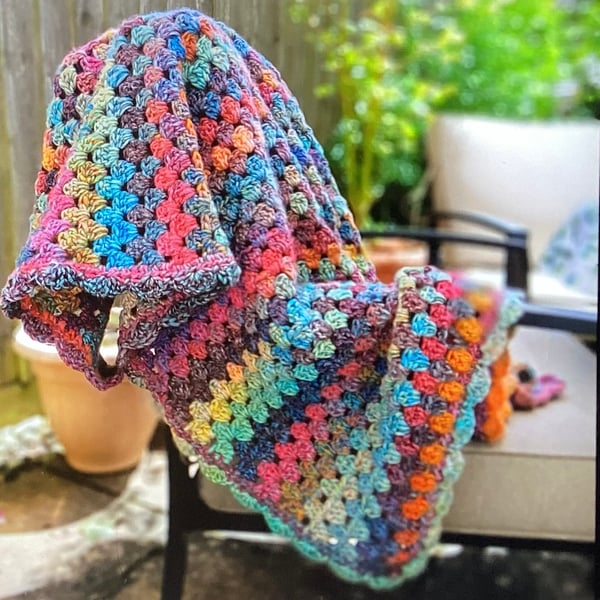 Lap blanket in jewel coloured chunky wool and acrylic.