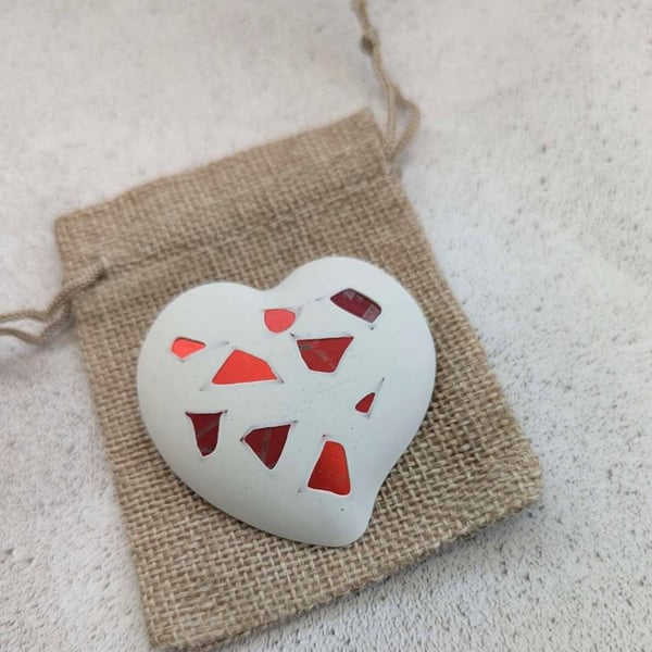 Handmade heart brooch crafted from smooth jesmonite and red aluminium pieces
